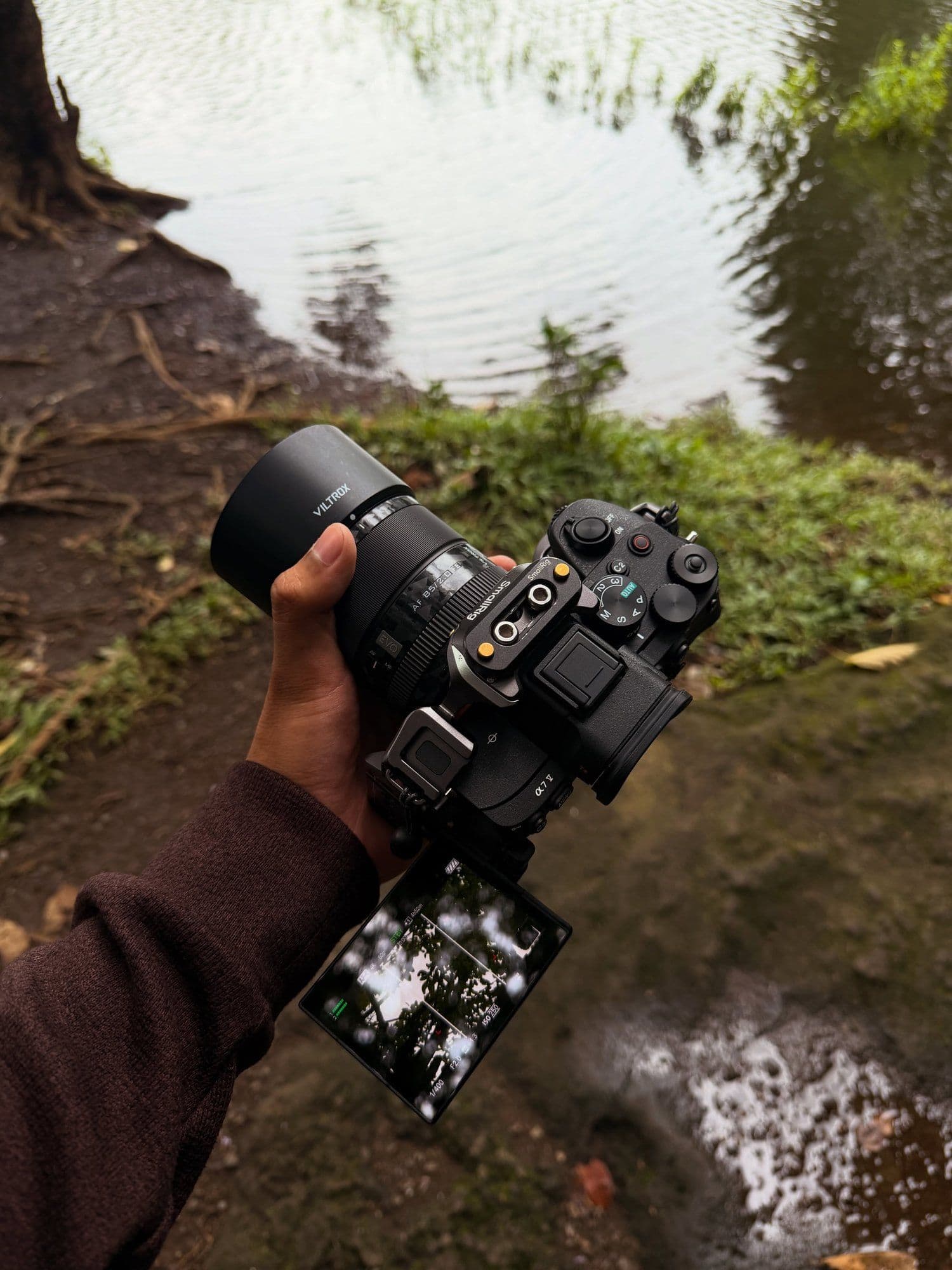 Camera held over a riverbank